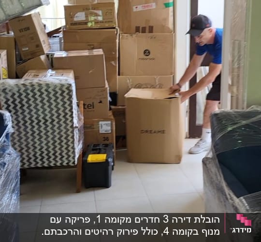 אדם מזיז קרטונים בחדר מלא ארגזים למעבר דירה